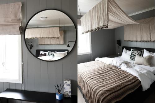 a bedroom with a large mirror and a bed at Solsiden Brygge Rorbuer in Ballstad