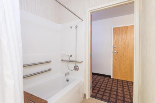 a white bathroom with a tub and a shower at Microtel Inn & Suites by Wyndham Uncasville in Uncasville