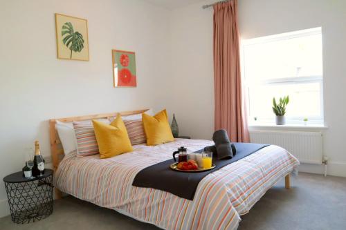 a bedroom with a bed with a tray of food on it at Modern New House - Great Location - Garden - Parking - Fast WiFi - Smart TV - Stunning 2 Bedroom House sleeps up to 4! Only 5 mins drive to Sandbanks Beach in Parkstone