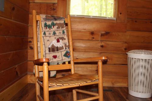 a wooden rocking chair sitting in a corner of a room at Country Road Cabins in Hico