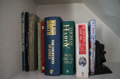 a group of books sitting on a shelf at Langshott Manor - Luxury Hotel Gatwick in Horley
