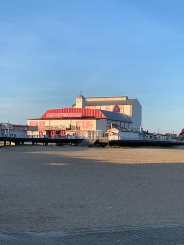 a pier with a building on the beach next to the water at OYO Twins Palms Guest House in Great Yarmouth