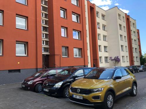 rząd samochodów zaparkowanych przed budynkami w obiekcie Pilies Kopų Apartamentai w Kłajpedzie