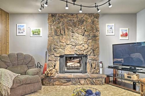 a living room with a large stone fireplace at Home with Serene Deck in Twain Harte! in Twain Harte