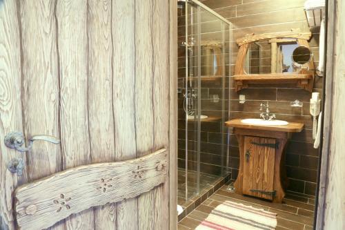 uma casa de banho em madeira com um lavatório e um chuveiro em Siberia em Estosadok