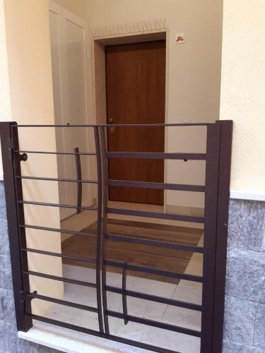 una barandilla metálica delante de una puerta en Casa Pompelmo Rosa, en Bernalda