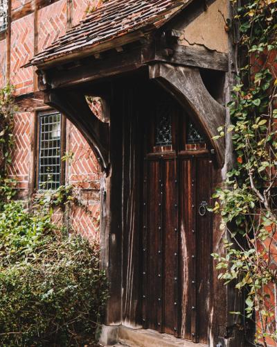 an old wooden door on the side of a building at Langshott Manor - Luxury Hotel Gatwick in Horley