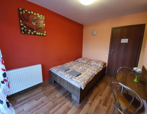 ein Schlafzimmer mit einem Bett in einem Zimmer mit orangefarbenen Wänden in der Unterkunft Albinos in Albigowa