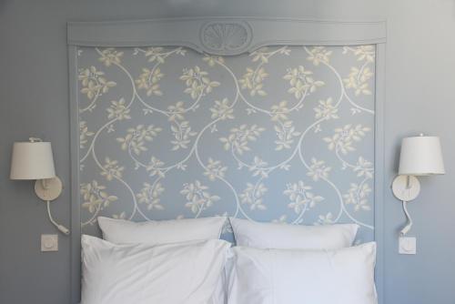 a bedroom with a headboard with a floral wallpaper at Le Charles V in Meursault