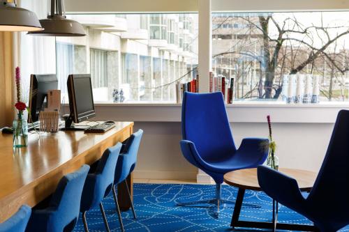 an office with blue chairs and a desk with a computer at Holiday Inn Express Rotterdam - Central Station by IHG in Rotterdam