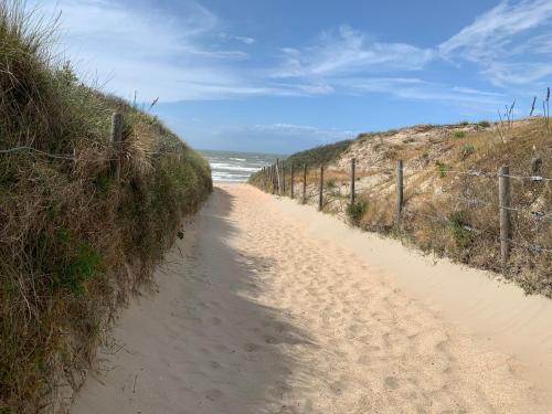 a dirt road leading to the ocean on a beach at Duinendaele 166 met sauna en bij Plopsaland in De Panne