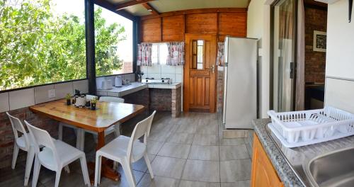 uma cozinha com uma mesa e um frigorífico em Palm Cottage - Colchester - 5km from Elephant Park em Colchester