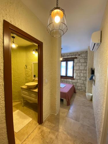 a bathroom with a sink and a bed and a mirror at ZEVKLİLER ALAÇATI hotel in Alacati