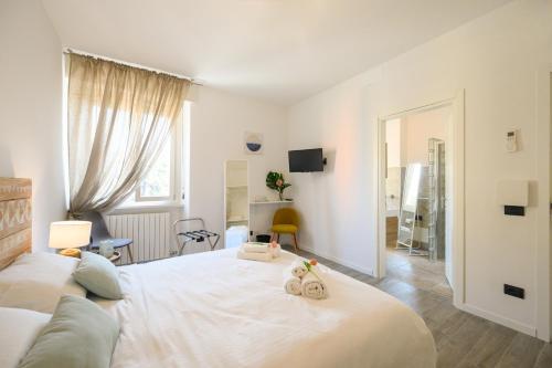 维罗纳Casa Porta Nuova Verona的一间白色卧室,配有两张床和镜子