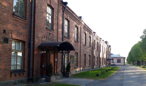 a brick building with an awning next to a street at Hotelli Rakuuna in Lappeenranta