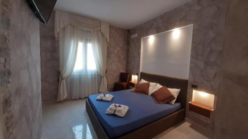 a bedroom with a blue bed with towels on it at Sardinia B&B house in Olbia