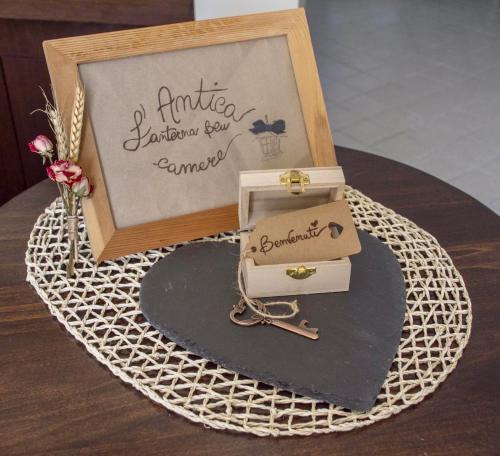 a table with a sign and a box with a key at Mini-Appartamenti, Camere Lanterna Blu in Mombello Monferrato
