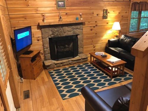 a living room with a couch and a fireplace at Country Road Cabins in Hico