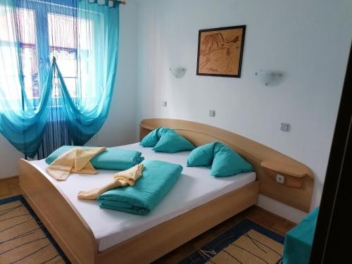 Una cama en una habitación con almohadas azules. en Rezidenca Ervin, en Jesenice