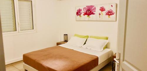 1 dormitorio con cama y ventana en T3 jardin Flamingo, en Saint-Paul