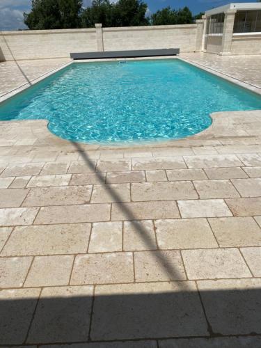 una piscina de agua azul en una acera en Le Terrazze Miramare B&B, en Torre Canne