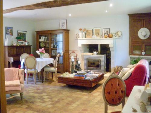 a living room with a table and a fireplace at La Metairie du Pont in Sainte-Hermine
