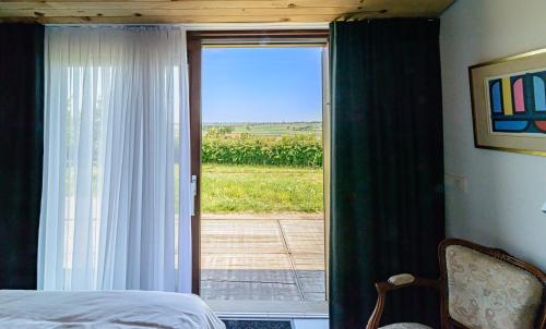 a bedroom with a bed and a sliding glass door at De Kleine Mote in Heuvelland