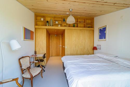 1 dormitorio con cama, silla y escritorio en De Kleine Mote, en Heuvelland