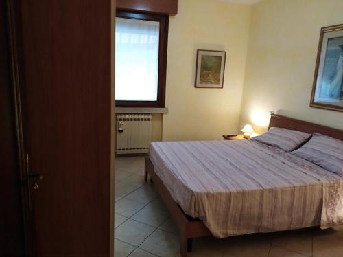 Un dormitorio con una cama grande y una ventana. en Perla Sirmione, en Sirmione