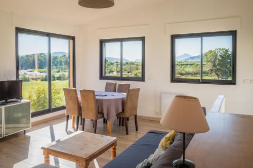 un salon avec une table, des chaises et des fenêtres dans l'établissement A 500m de la plage, à Hyères