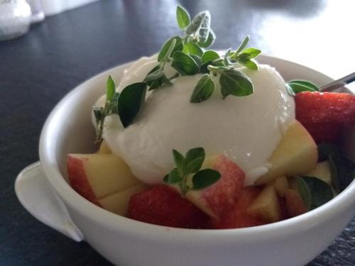 a bowl of ice cream and fruit on a table at B&B De Vossenbarm in Jabbeke