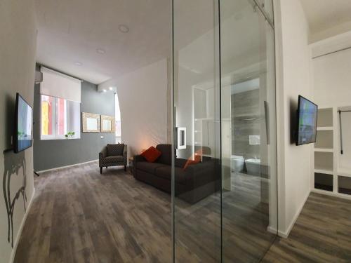 a living room with a couch and a glass wall at Space Suite in Cagliari