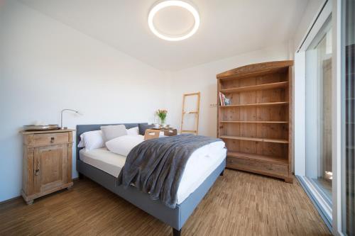 een slaapkamer met een bed en een boekenplank bij Heislerhof Apartment in Mösern