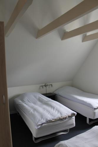 two beds in a room with white walls at Odense Apartments in Odense