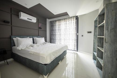 een slaapkamer met een groot bed en een groot raam bij Yaraşır Family Suite in Didim