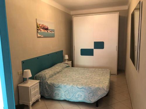 1 dormitorio con cama, mesita de noche blanca y puerta en Ca' da Nuccia, en Riomaggiore