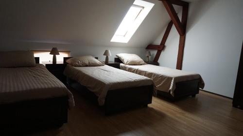 a hotel room with two beds and a skylight at Agro na Wapniarni in Białla