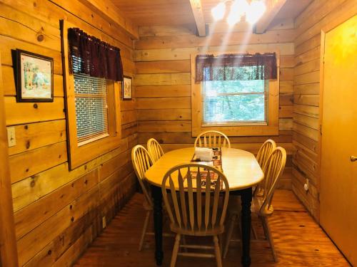 a dining room with a table and chairs in a cabin at Country Road Cabins in Hico