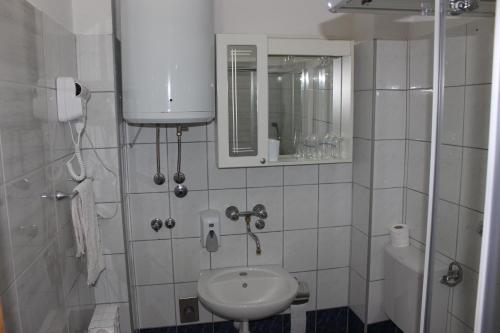 ein Badezimmer mit einem Waschbecken, einem WC und einem Spiegel in der Unterkunft Hotel San in Trebinje