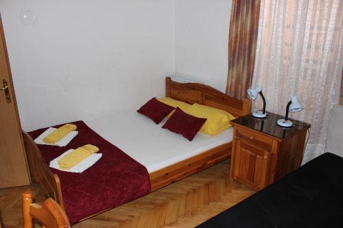a bedroom with a bed and a nightstand with a bed sidx sidx at Hotel San in Trebinje