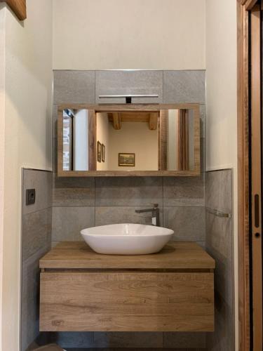 een badkamer met een wastafel en een spiegel bij LA DRIT in Paesana