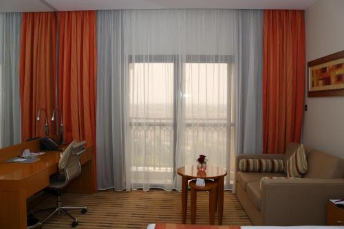 a living room with a couch and a table in front of a window at Crowne Plaza Sohar by IHG in Sohar