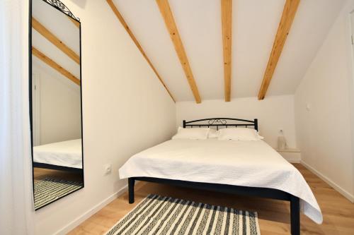 een slaapkamer met een bed en een spiegel bij Apartment Lavanda - Suite in Sinj