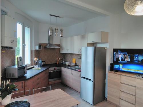 a kitchen with a stainless steel refrigerator and a table at Apartament Meluzyna in Puck