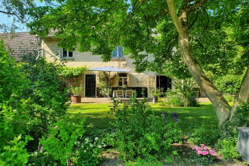 a house with a yard with flowers and trees at Boutique Hotel Bonjour in Gronsveld