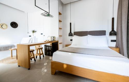 a bedroom with a large bed and a desk at Eleana Hotel in Tinos Town