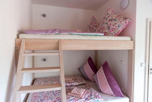 two bunk beds in a room with pillows at Apartmán u Větrníku in Jihlava