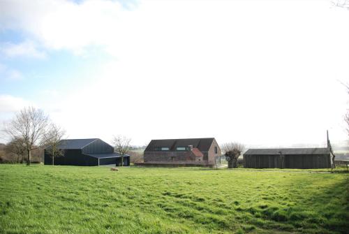 a large field with a house and a barn at Domein De Kleine Mote in Heuvelland