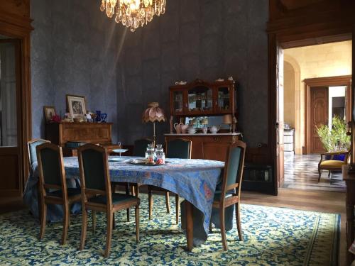 a dining room with a blue table and chairs at Château de Couin in Couin
