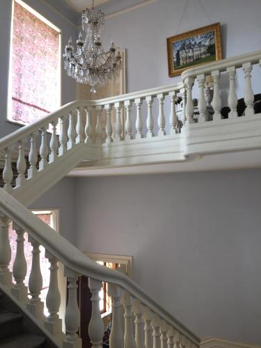 - un escalier dans une maison dotée d'un lustre dans l'établissement Château de Couin, à Couin